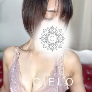 横浜センター南メンズエステCIELO | センター南シエロ Promotional fashion photo of a female model with short dark hair wearing a lace top; a decorative mandala design covers her mouth in soft lighting.