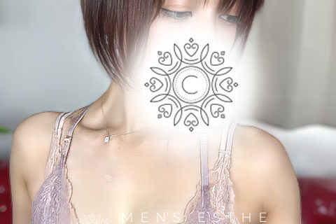 Promotional fashion photo of a female model with short dark hair wearing a lace top; a decorative mandala design covers her mouth in soft lighting.