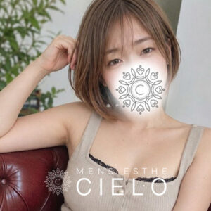 横浜センター南メンズエステCIELO | センター南シエロ Woman in a beige tank top lounging on a red couch with a decorative mandala-like design printed over her mouth, used as branding for a spa.
